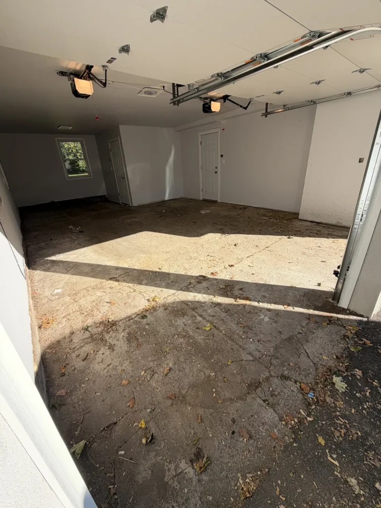 Stained bare concrete garage floor in Great Neck before a urethane cement flake coating
