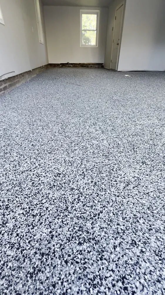 Close view of a black, white and gray flake urethane cement garage floor in Great Neck